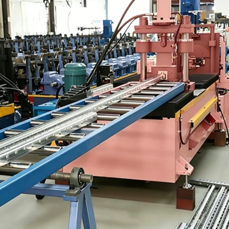 Shelf Rack Roll Forming Machine, a high-precision industrial equipment specialized in mass production of shelf rack uprights. The machine features a robust steel frame, integrated PLC control system with touchscreen interface, and multi-station forming rolls, showing its compact and professional structure. It is widely used in manufacturing high-quality structural components for industrial warehouses, commercial storage racks and logistics centers, with stable performance and high production efficiency.