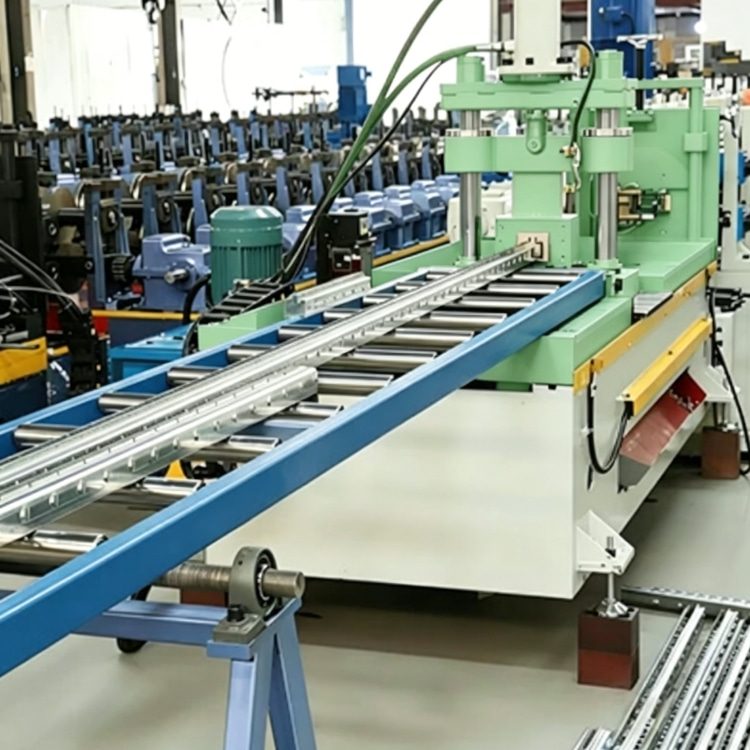 Shelf Rack Roll Forming Machine, a high-precision industrial equipment specialized in mass production of shelf rack uprights. The machine features a robust steel frame, integrated PLC control system with touchscreen interface, and multi-station forming rolls, showing its compact and professional structure. It is widely used in manufacturing high-quality structural components for industrial warehouses, commercial storage racks and logistics centers, with stable performance and high production efficiency.